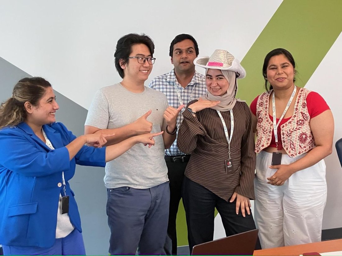 Hadeel in a cowboy hat with four AIR colleagues, celebrating