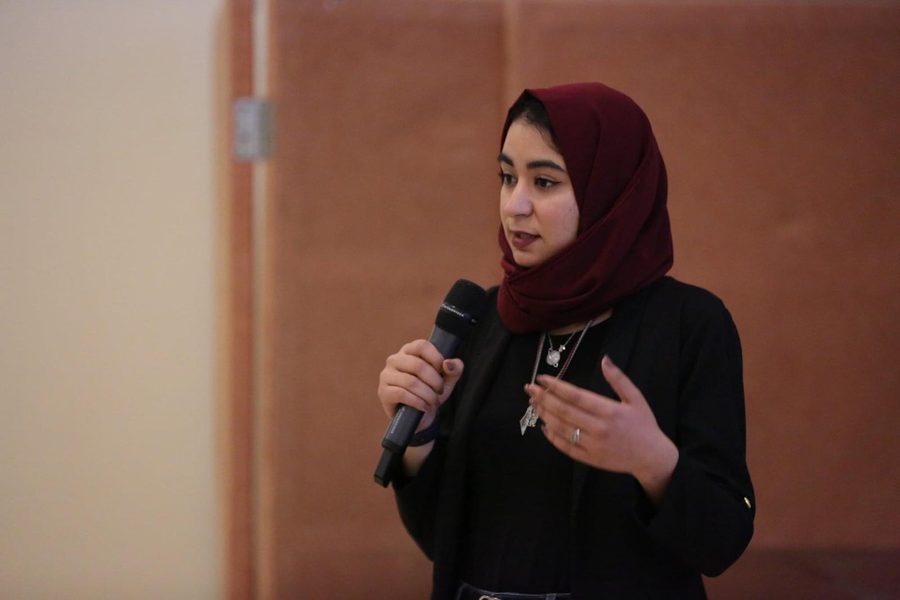 Hadeel speaking into a microphone while presenting her capstone project