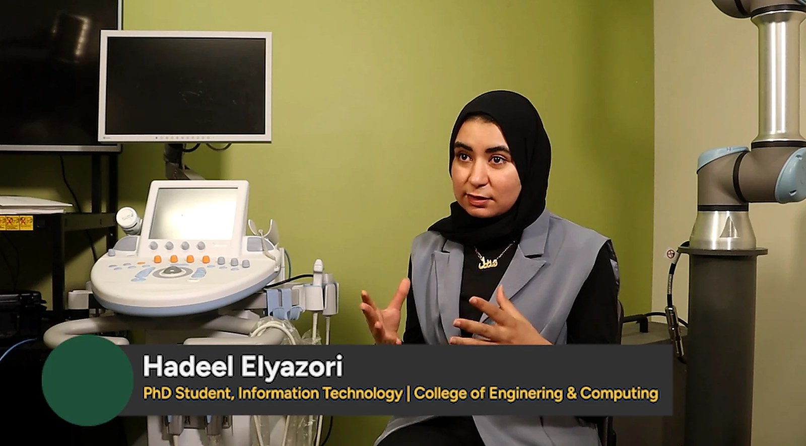 Hadeel speaking on camera in a research lab, gesturing as she explains