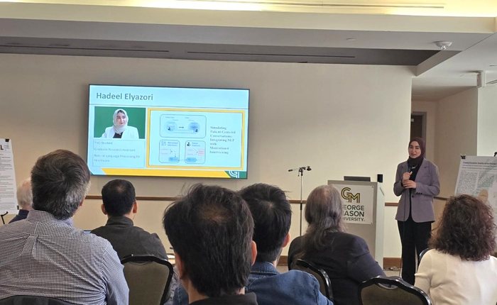 Hadeel presenting at the IST PhD Symposium beside a slide titled Simulating Patient-Centered Conversations